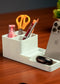 White desk organizer with phone stand, pens, scissors, and other items on a wooden surface.