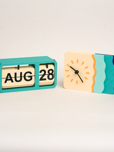 Waveform Horizon desk clock with layered wave design in blue tones and FlipFrame retro desk calendar in teal