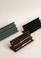 Wooden pen holder with three pens on a white background