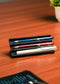 Wooden pen holder with three pens on a beige background