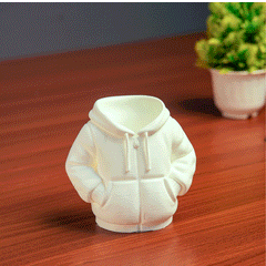 Black hoodie-shaped pen holder with stationery items on a light pink background