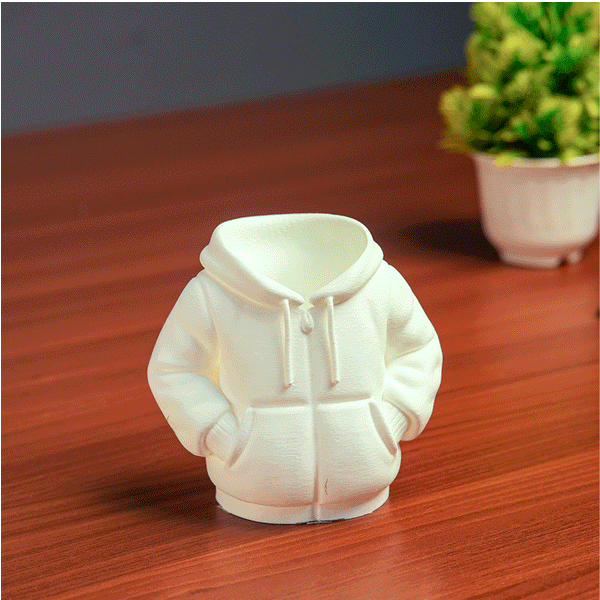 Black hoodie-shaped pen holder with stationery items on a light pink background