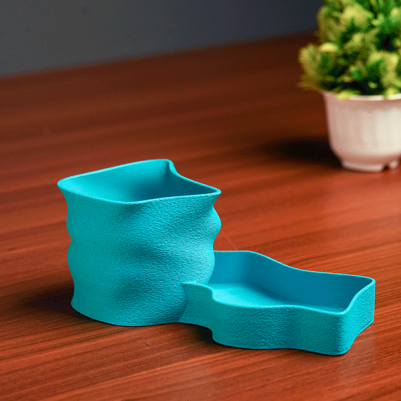 Teal pen holder with stationery items on a light background
